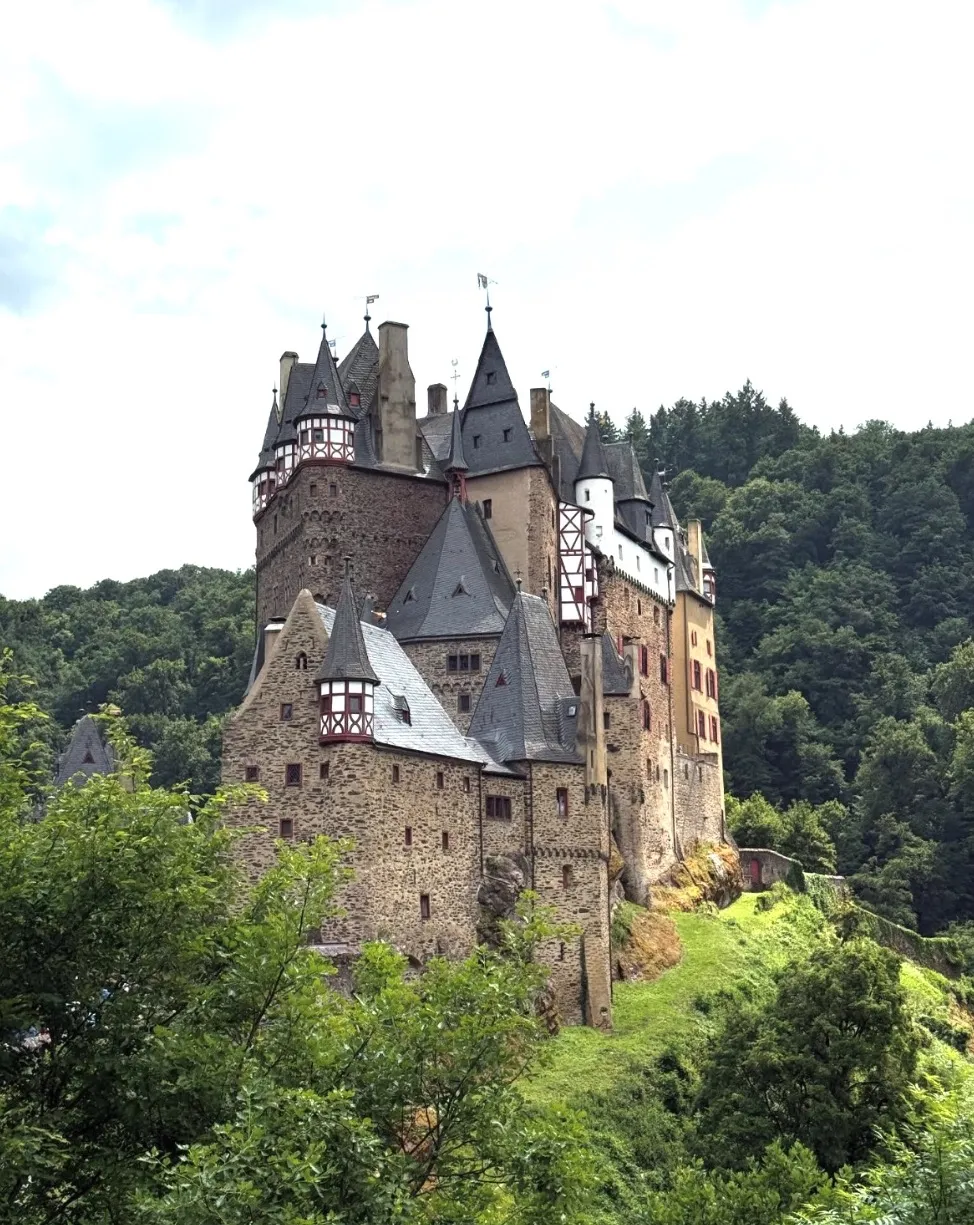 Burg Eltz castle rising out of a green forest